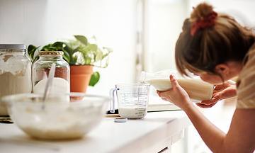 woman pouring ingredients into measuring cup