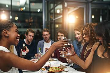 friends gathered around table toasting glasses