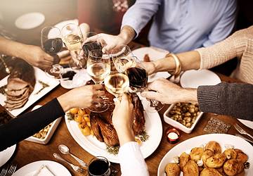 People toasting glasses around table
