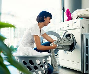 Woman putting laundry in dryer