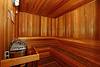 A wooden sauna interior with benches and a heater.