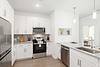 Modern kitchen with white cabinets, stainless steel appliances, and a clean design.