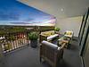 A cozy balcony with comfortable seating and beautiful sunset views.