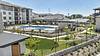 A modern apartment complex featuring a large swimming pool and landscaped areas.