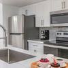 Apartment kitchen with stainless steel appliances and white cabinetry