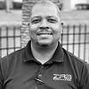 man wearing polo shirt with name tag clipped to collar
