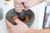 person using mortar and pestle