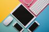 Apple mouse, iPad, iPhones, and keyboard on colorful background