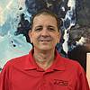 Man with dark hair wearing red shirt