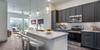 Kitchen island with pendant lighting and dark cabinetry