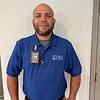 man wearing blue shirt and nametag