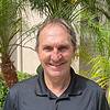smiling man in front of palm trees