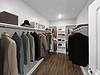 A neatly organized closet featuring various coats and accessories.