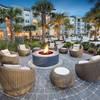 Outdoor firepit with wicker chairs and tables.