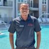 smiling man with polo shirt in front of pool