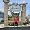 man with red shirt standing in front of property signage