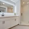 Bathroom with white cabinets and walk-in shower. 
