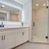 Bathroom with white cabinets and a walk-in shower. 