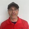 Man wearing black baseball cap and red shirt