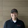 smiling man in baseball cap and polo shirt