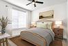 A cozy, well-decorated bedroom featuring a bed, nightstands, and natural light.