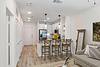 Modern kitchen and living area with bar stools, a sofa, and decorative elements.