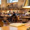 book on table in library with lamp and chair