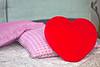 Pink pillow and heart pillow on couch