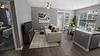 Modern living room and dining area with stylish decor and natural lighting.