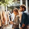 couple viewing paintings on display outside