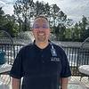 man wearing polo shirt with name tag clipped to collar
