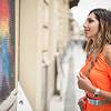 Woman looking at art on wall outside