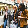 three women walking with shopping bags