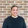 smiling man with hair in ponytail