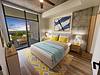 Modern bedroom with a scenic view, featuring stylish decor and soft lighting.