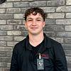 man wearing black polo shirt and name tag