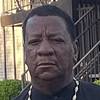 man with short hair and bead necklace