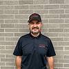 man with short beard and black polo shirt and cap