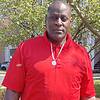 man wearing red shirt and necklace