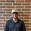 man wearing black polo shirt and light colored cap