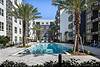 apartment complex with pool area surrounded by palm trees