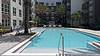 apartment complex with pool area surrounded by palm trees