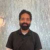 smiling man with beard and polo shirt