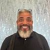 smiling man with white beard and glasses on head