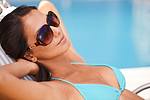 woman tanning by the pool in a blue bikini