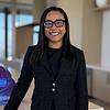 smiling woman with glasses and dark jacket