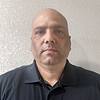 man with no hair wearing polo shirt
