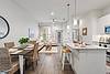 open kitchen and dining area, featuring light decor and cozy furnishings.