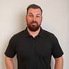 man with short hair, beard, and polo shirt