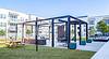 A modern outdoor patio area with grilling stations and seating in an apartment complex.